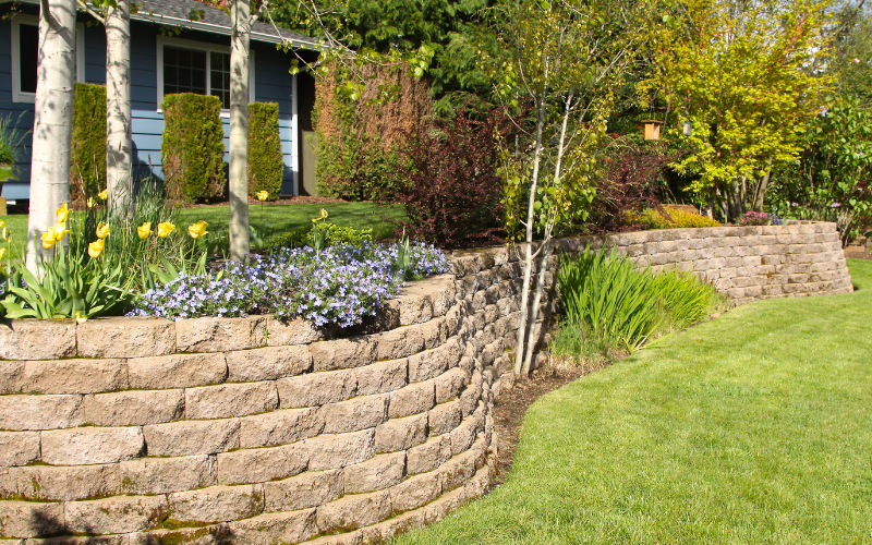 cobblestone retaining wall in landscaped yard